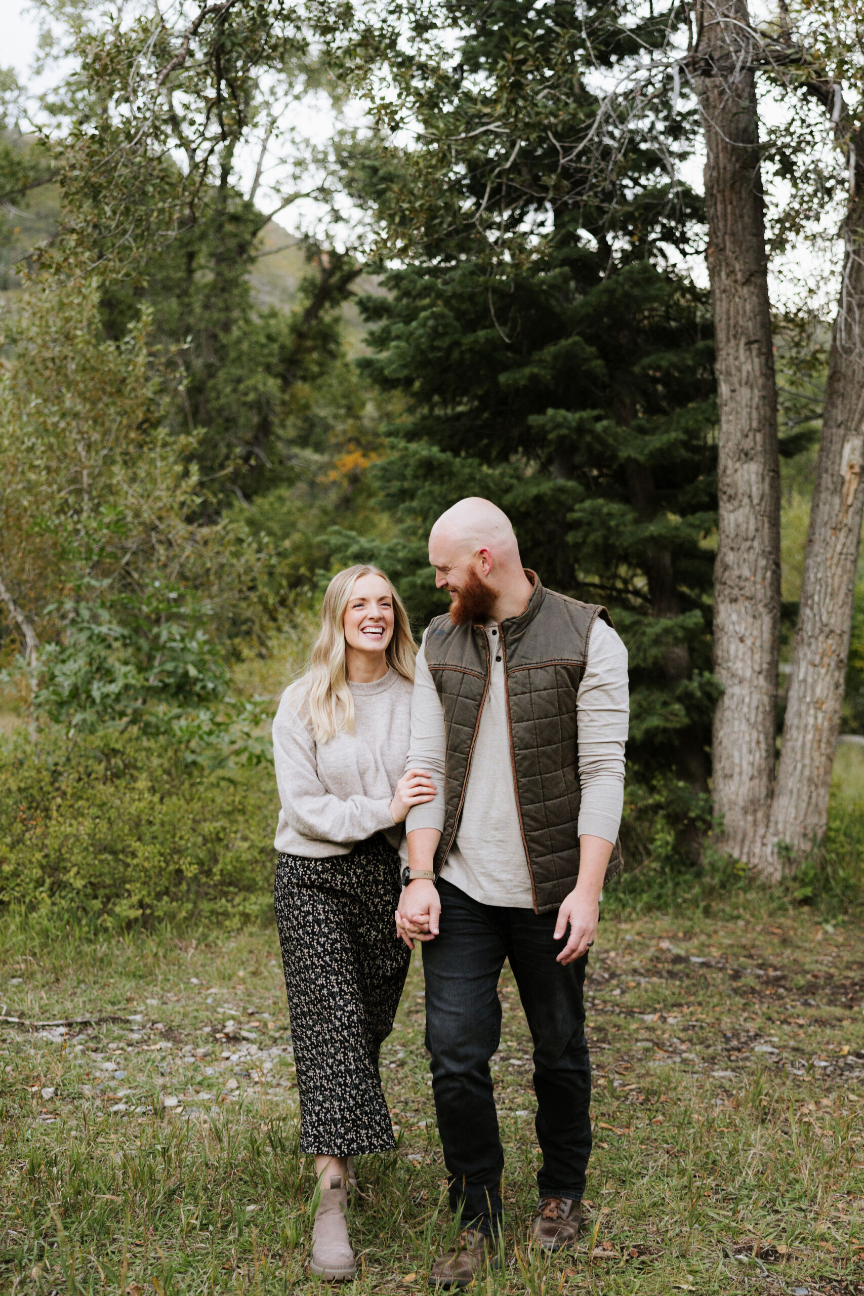 Man and Woman holding hands and walking towards camera while smiling