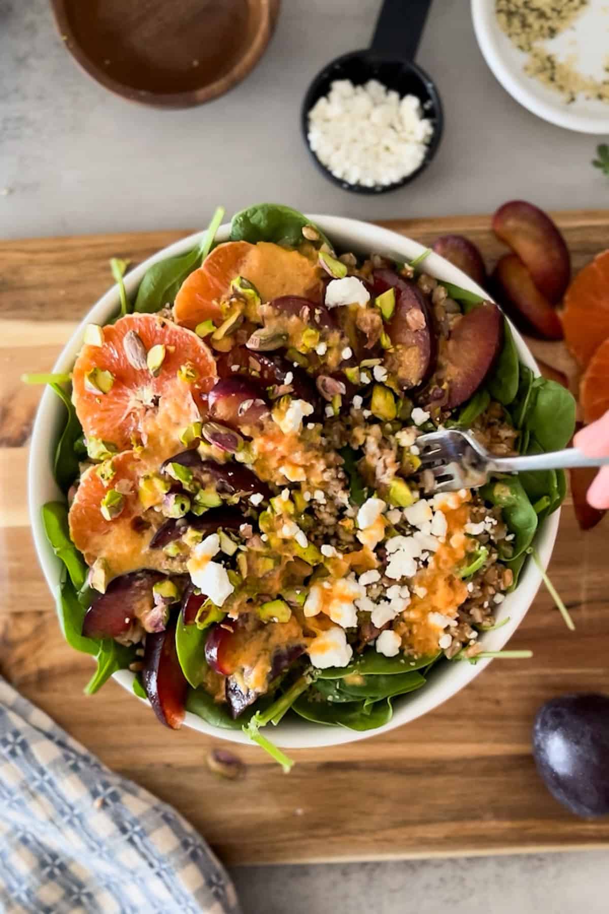 top down shot of fork poking into plum arugula salad